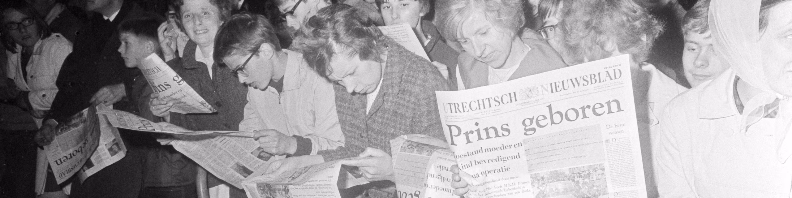 Mensen lezen kranten over de geboorte van een prins