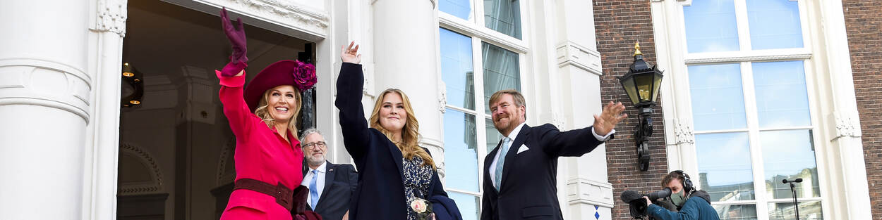 Queen Máxima, The Princess of Orange and King Willem-Alexander waving at the crowd in front of the entrance of the Council of State
